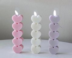 three heart shaped candles sitting next to each other