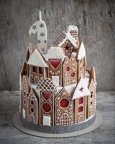 a decorated cake sitting on top of a wooden table covered in frosting and icing