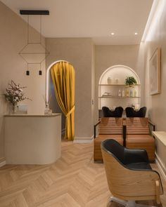 the interior of a hair salon with wooden floors and yellow drapes on the windows