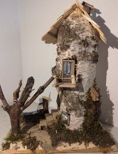 a house made out of wood and branches with a window on the top of it