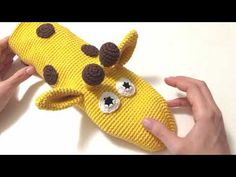 someone is holding up a stuffed animal made to look like a banana with googly eyes