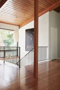 an empty living room with wood floors and white walls is pictured in this image from the inside