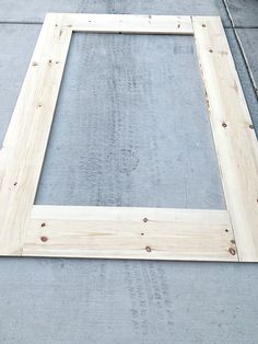 a wooden frame sitting on top of a sidewalk