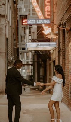 a man and woman dancing in an alleyway