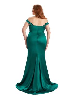 a woman in a long green dress with her back to the camera, looking down