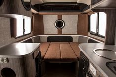 the inside of a motor home with kitchen and dining area in it's center