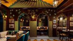 the interior of a fancy restaurant with striped furniture and walls painted in gold, blue, and green