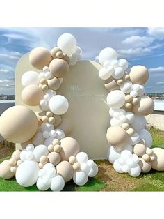 an arch made out of balloons in the grass