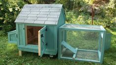 a blue chicken coop in the grass