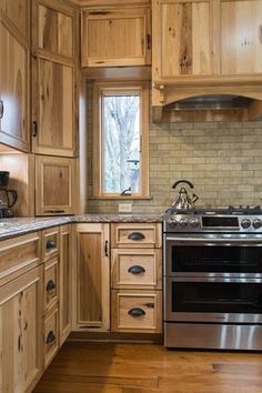 a kitchen with wooden cabinets and stainless steel stove top oven in the center of the room