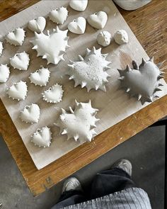 a wooden table topped with lots of white frosted snowflakes on top of a cutting board