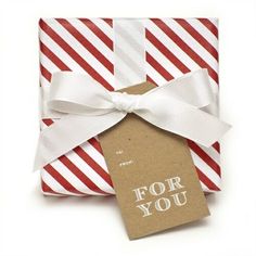 a christmas present wrapped in red and white striped paper with a tag that says merry bright to from