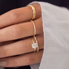 a woman's hand with three different rings on it