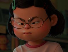 a close up of a child wearing glasses and looking at something in front of her