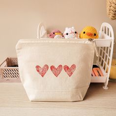 a bag with hearts drawn on it sitting on a table next to some toys and books