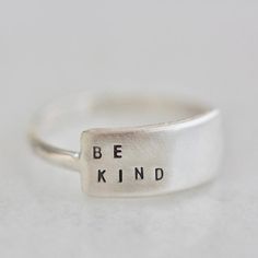 The Cherished inspiRING makes for the perfect everyday ring that features your favorite little reminder.Designed to be the little sister to the wide inspiRING, this ring will be one you cherish for years to come. Letters are individually stamped by hand, making each ring one of a kind. The message is left justified in our signature teeny-tiny upper case block font. Choose one of our messages or create your own https://www.etsy.com/listing/896794788 .details+ message plate measures 5/8" wide x 1/