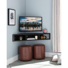 a flat screen tv sitting on top of a wooden shelf next to two stools