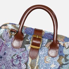 a handbag with a floral pattern and brown leather handles