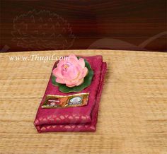 a pink flower sitting on top of a red cloth