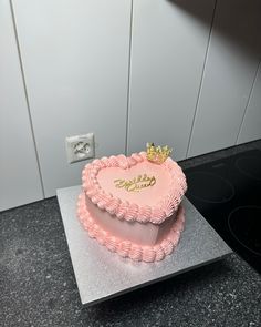 a pink heart shaped cake sitting on top of a counter