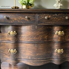 an old wooden dresser with brass handles and knobs on it's drawers, in a living room