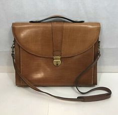 a brown leather briefcase sitting on top of a white table