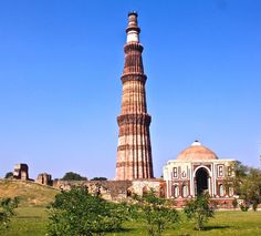 a tall tower sitting in the middle of a lush green field