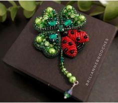 a brooch with two ladybugs on it sitting on top of a book