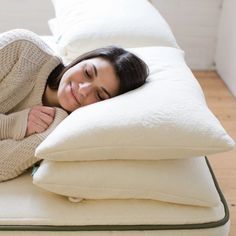 a woman laying on top of two pillows