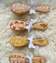 four wooden spoons decorated with flowers and ribbons