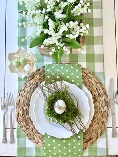 the table is set with white flowers and green napkins