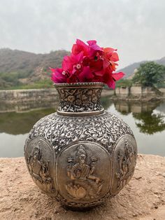 a vase with flowers in it sitting on a rock