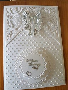 a white wedding card with a butterfly on the front and an ornate design in the back