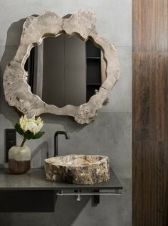 a bathroom with a sink, mirror and wooden cabinet in it's centerpiece