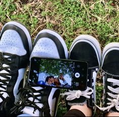 three pairs of shoes are sitting next to each other and one person is taking a photo with their cell phone