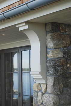 an outside view of a house with stone walls and windows, along with a door that leads to the water