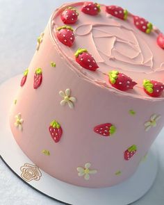 a pink cake decorated with strawberries and flowers