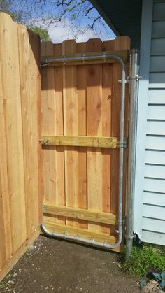 a wooden fence with metal pipes attached to it