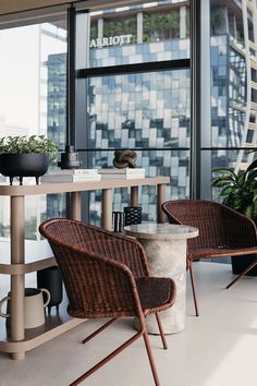 two wicker chairs sitting next to each other on top of a table in front of a window