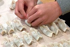 a person is making dumplings on a table