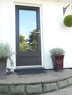 a black front door with two planters next to it