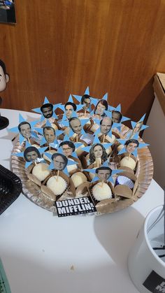 a table topped with cupcakes and pictures of men in hats on top of paper plates