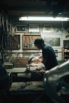 a man working in a workshop with lots of tools