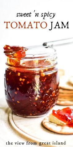 a glass jar filled with jam next to crackers