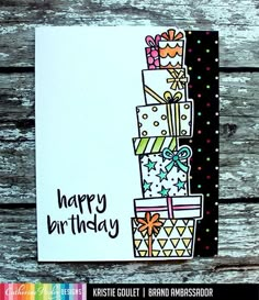 a handmade birthday card with presents and confetti on it, sitting on a wooden table