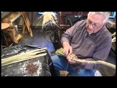 an older man sitting in a chair working on something with wood shavings next to him