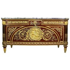 an ornately decorated chest with gold and red paint on the front, featuring a golden head