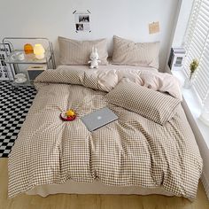 a laptop computer sitting on top of a bed next to pillows and pillowcases