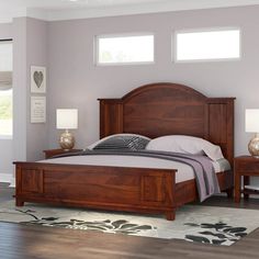 a large bed sitting in a bedroom next to two nightstands on either side of the bed