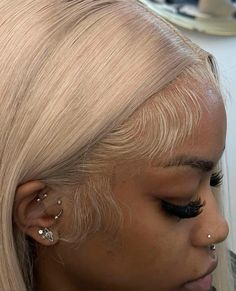 a woman with blonde hair and piercings on her ears